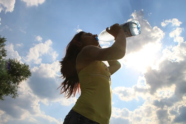 person drinking water in sunlight for hydration and energy